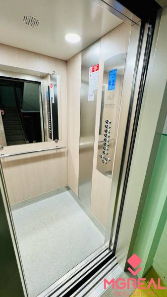 Interior of an elevator with a control panel and mirror, suitable for a 2-room apartment.
