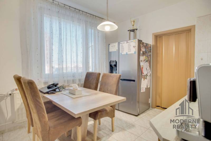 Kitchen in a 3-room apartment with a dining table and a refrigerator.