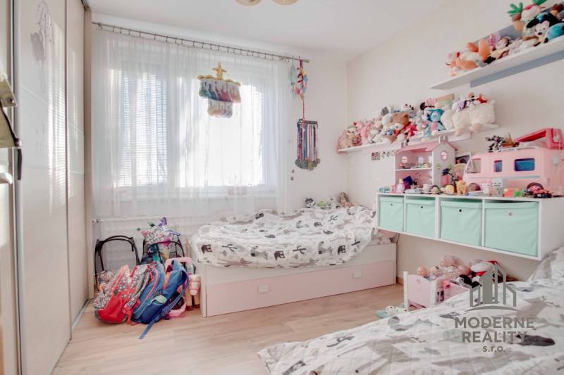 Children's room in a 3-room apartment with toys and a bed, floor with wooden decor.