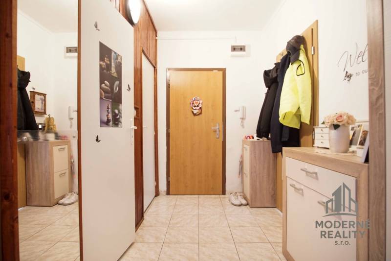 The entrance hall of a 3-room apartment with tiles and storage cabinets.