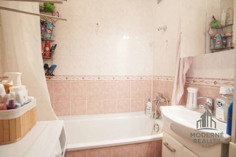Bathroom with a bathtub, sink, and storage space in a 3-room apartment.