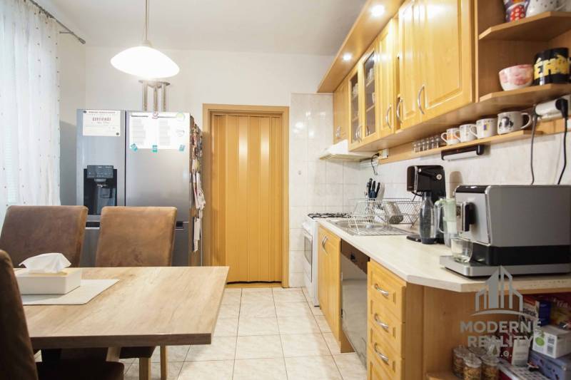 A kitchen in a 3-room apartment, equipped with wooden cabinets and built-in appliances.