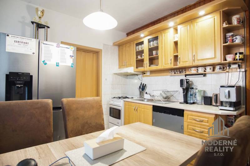 A kitchen in a 3-room apartment with wooden cabinets and modern equipment.