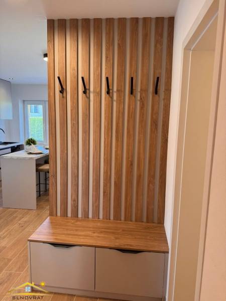 An entrance hall in a 2-room apartment with a slat wall and a chest of drawers with storage space.