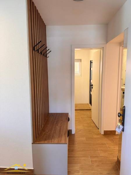 Entrance hallway with a hanging system and floor with wood decor in a 2-room apartment.