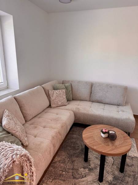 Comfortable light sofa and table with decoration in a 2-room apartment.