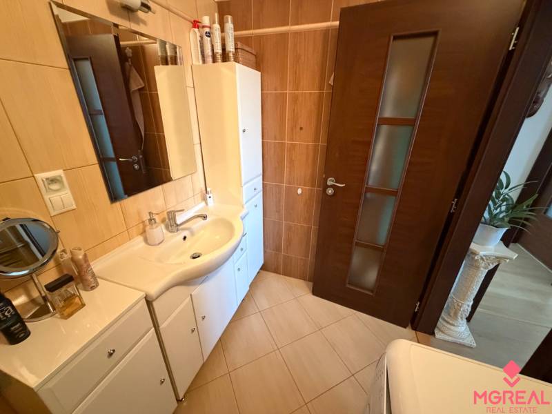 A bathroom in a 3-room apartment with white furniture and dark doors.