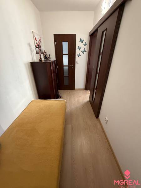 A hallway in a 3-room apartment with doors, butterfly decorations, and a wooden-patterned floor.