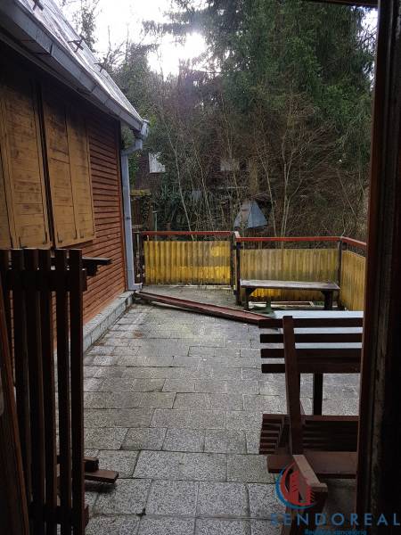 Terasa chaty na Výtockej ulici, Moravany nad Váhom s dreveným dekorom a okolitou zeleňou.