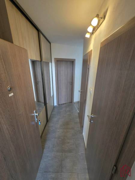 A hallway in a 2-room apartment with tiles and a built-in wardrobe with mirrored doors.
