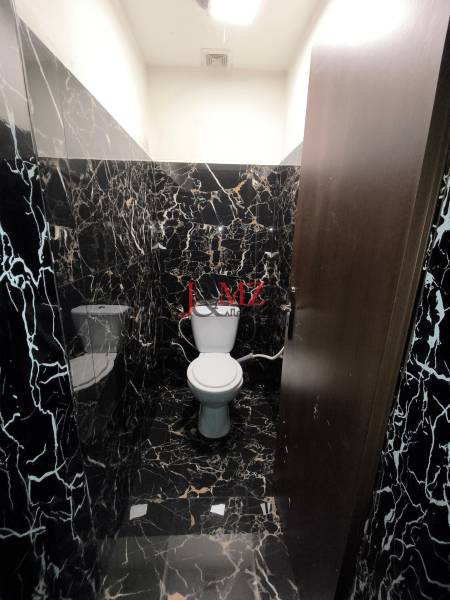 A toilet in a family house with black marble cladding and tiles.