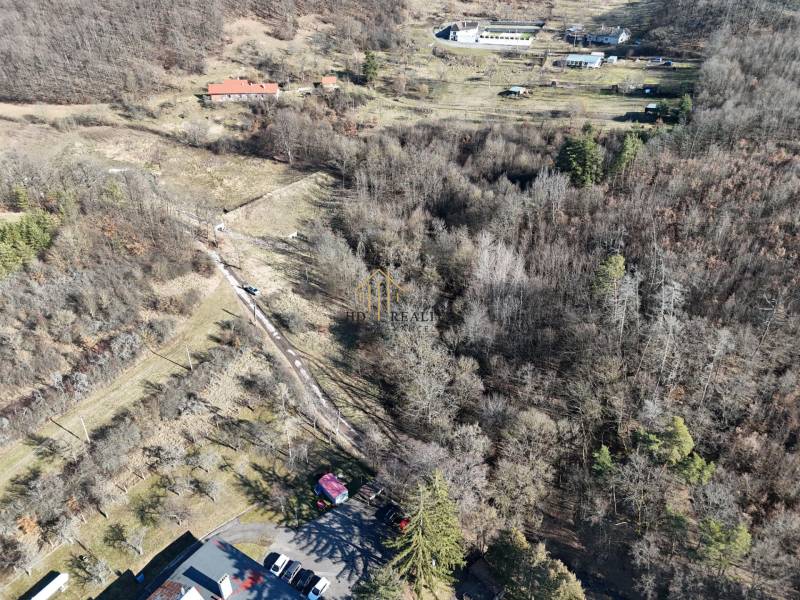 Aerial view of residential plots in Krupina surrounded by forest vegetation.