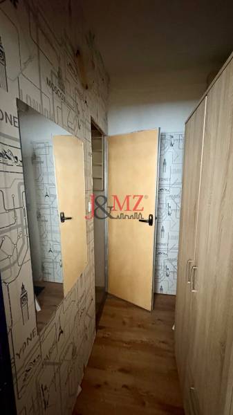 A studio apartment with travel-themed walls and a wooden decor floor.