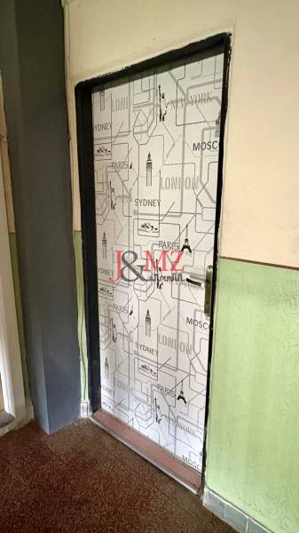 Doors covered with a city motif, floor with a wooden decor, wall in a deep green color.