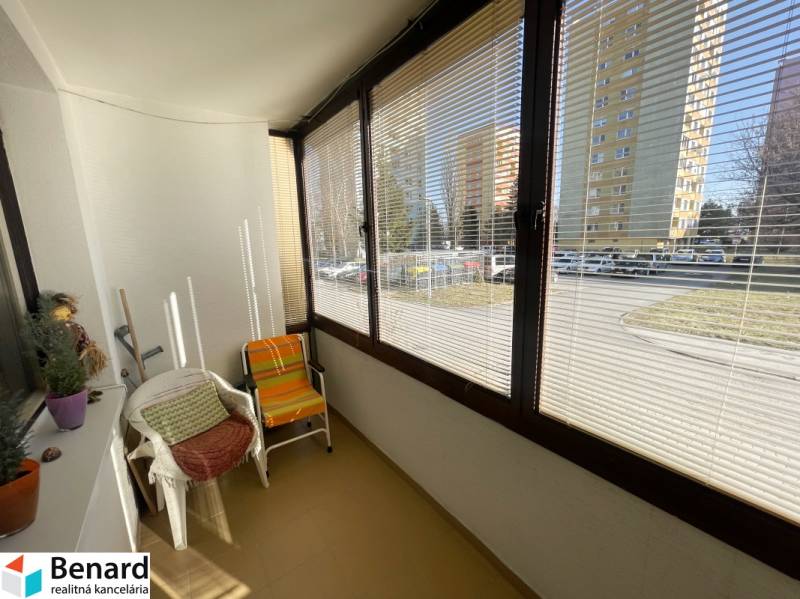 Glazed loggia in a 3-room apartment with a street view, equipped with armchairs.