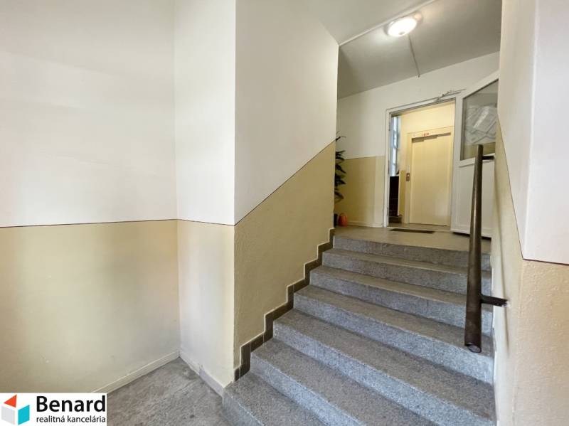 Entrance hall with staircase and access to the elevator in a 3-room apartment.