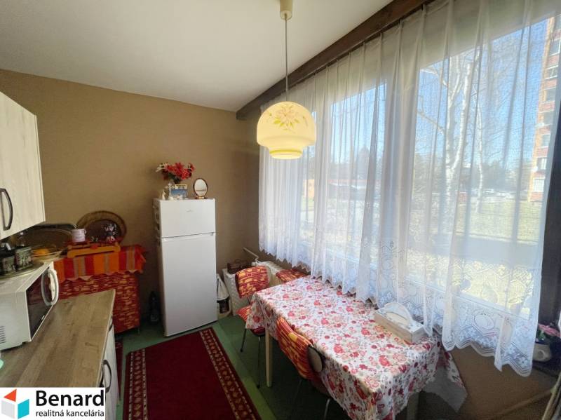Kitchen in a 3-room apartment with a dining table and a large window.