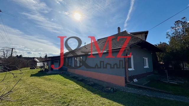 A family house in Mýtne Ludany with a grassy garden and a brick facade.