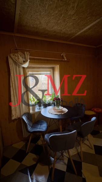 Dining area in a family house with patterned flooring and chairs around a round table.
