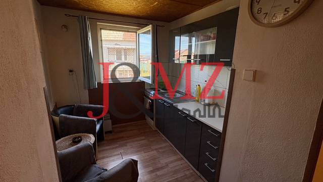 A kitchen with a wood-patterned floor and dark cabinets in a family house.