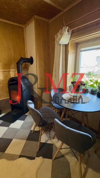 Fireplace in the living room of a family house with a round table and two chairs.
