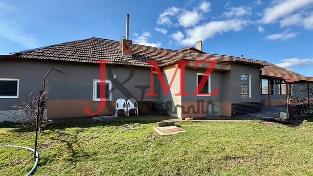 A family house in Mýtne Ludany with a spacious garden under a clear blue sky.