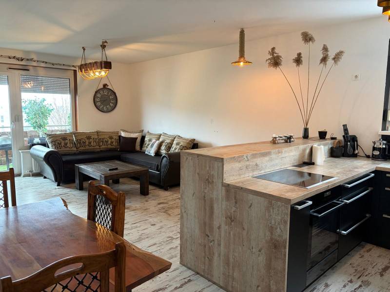 Kitchen with dining area in a 3-room apartment, floor with wood decor, comfortable sofa.