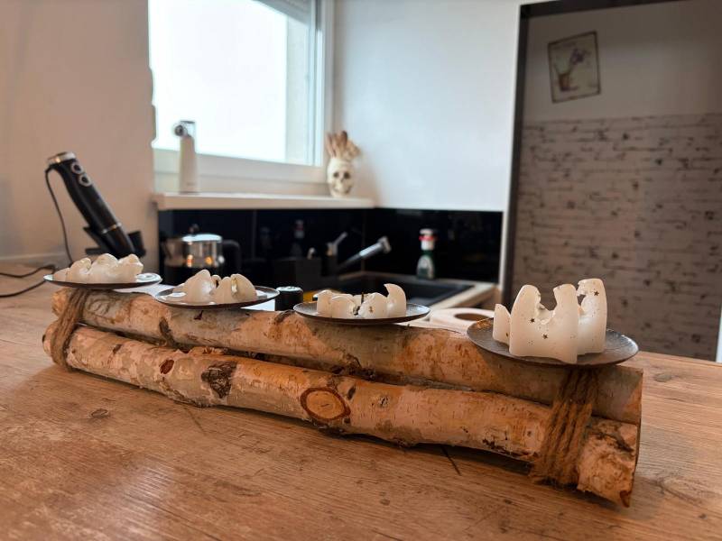 Wooden decor with white candles on a wooden table in the kitchen of a 3-room apartment.