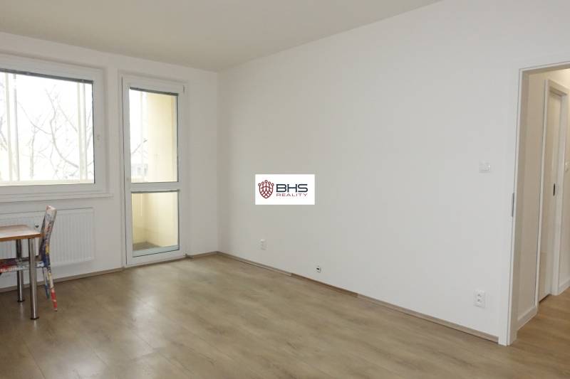 A room with a wooden floor design in a 3-room apartment, a table and a chair.