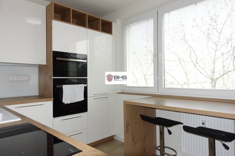 Kitchen in a 3-room apartment with white cabinets and a wood-patterned floor.