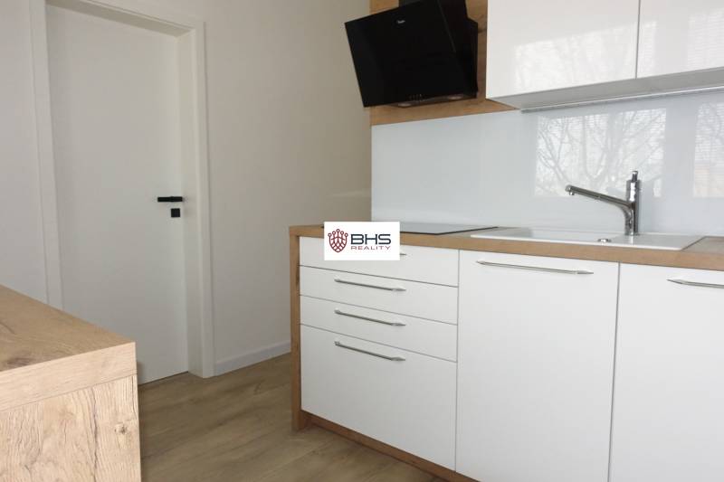 A kitchen unit with a wooden decor floor in a 3-room apartment.