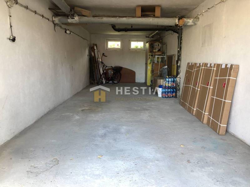 A garage in a 3-room apartment with stored items and a bicycle.