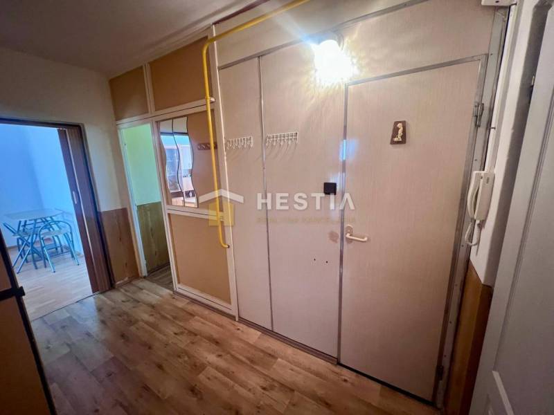 A hallway in a 3-room apartment with a coat rack, a mirror, and interior doors.