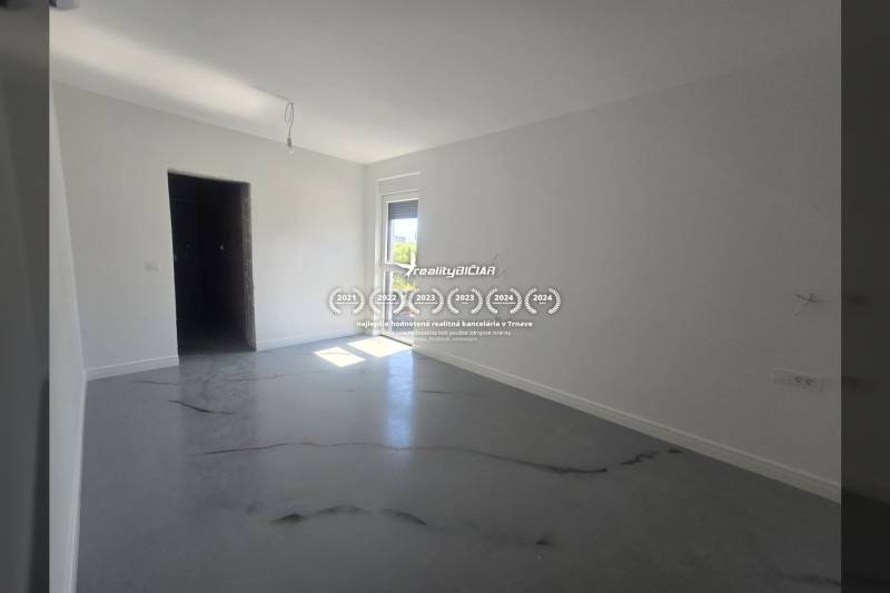 Spacious room in the villa with white walls and a floor with a wooden decor.