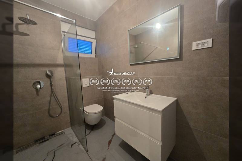 Bathroom in the Villa with a toilet, shower, and sink, flooring with a stone pattern.