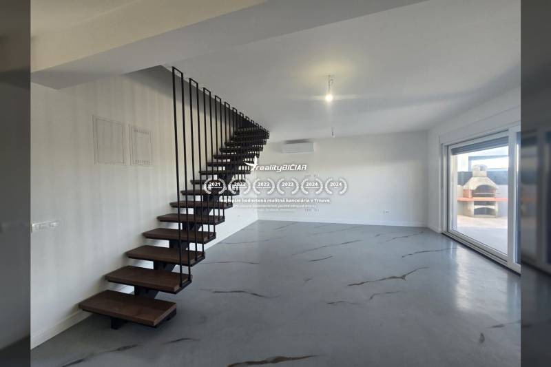 Interior of a villa with a metal staircase and a wooden decor floor, large window to the terrace.
