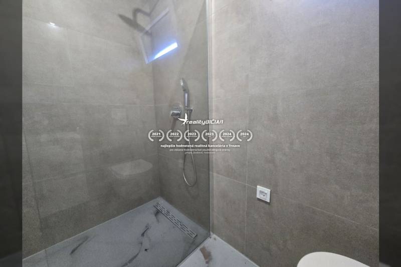 Shower enclosure with a transparent screen and gray tiles in the Villa.