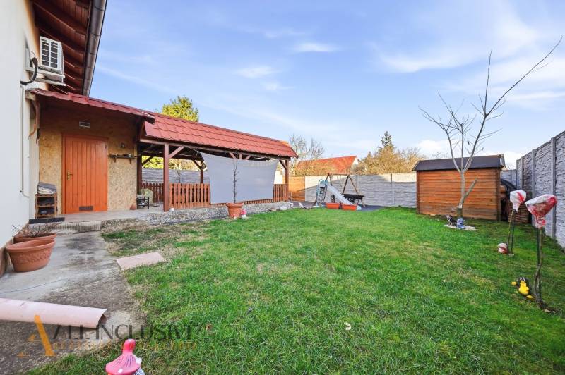 The garden of a family house in Hviezdoslavov with a lawn, a gazebo, and a children's playground.