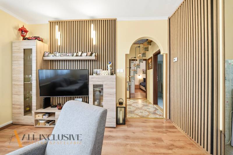 Living room in a family house with a television and a floor with a wooden decor.