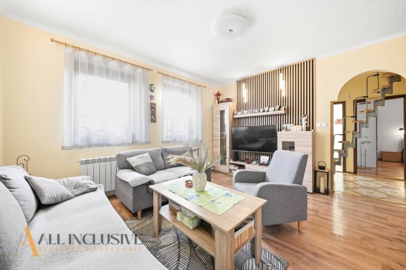 Living room in a family house with a sofa, table, television, and floor with a wooden decor.