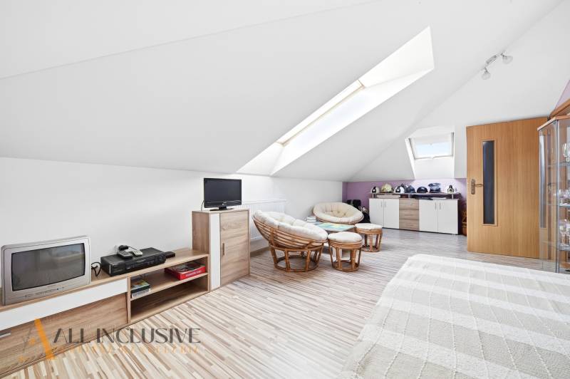 An attic room in a family house with armchairs and a wooden decor floor.