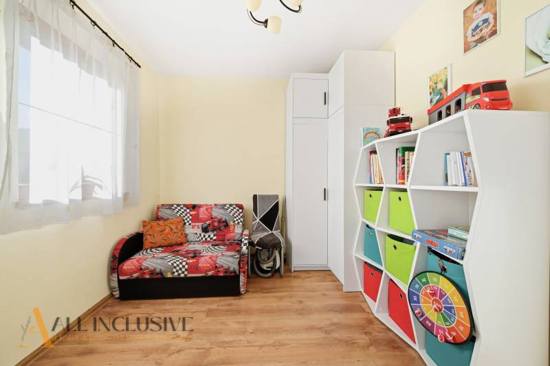 Children's room in a family house with colorful furniture and a wooden decor floor.