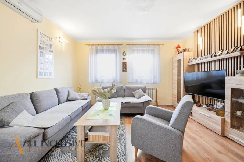Living room in a family house with a comfortable gray sofa and a wooden decor floor.
