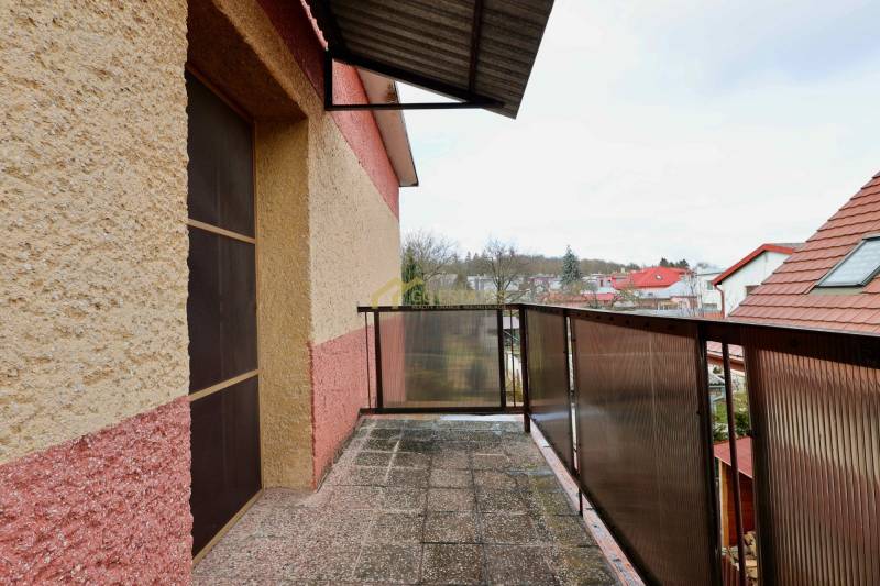 A balcony of a family house on Kalinčiakova Street in Michalovce with a view of the rooftops of houses.