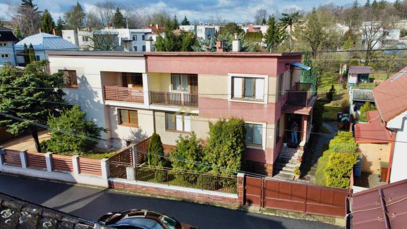 A family house on Kalinčiakova Street in Michalovce, with a landscaped front garden and a wooden fence.