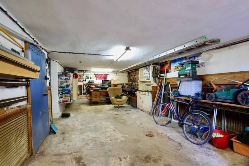 Garage in a family house with tools, a bicycle, and a workbench.