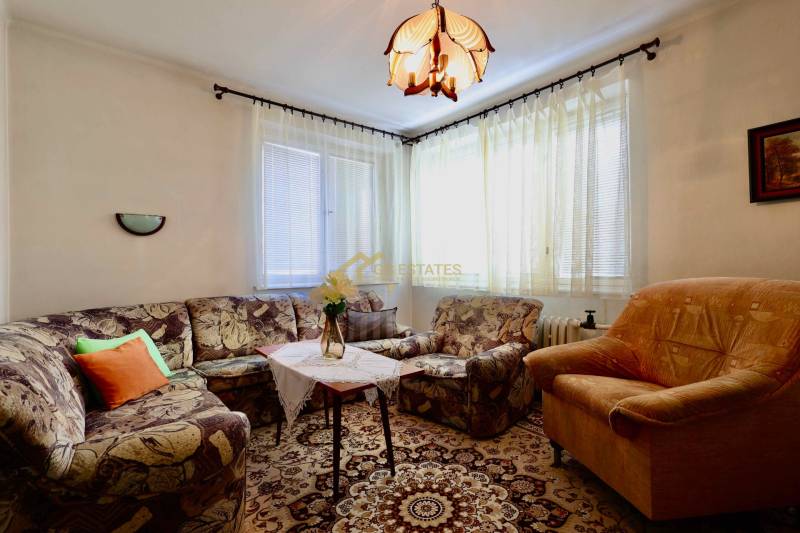 Living room in a family house with comfortable upholstered furniture and a decorative carpet.