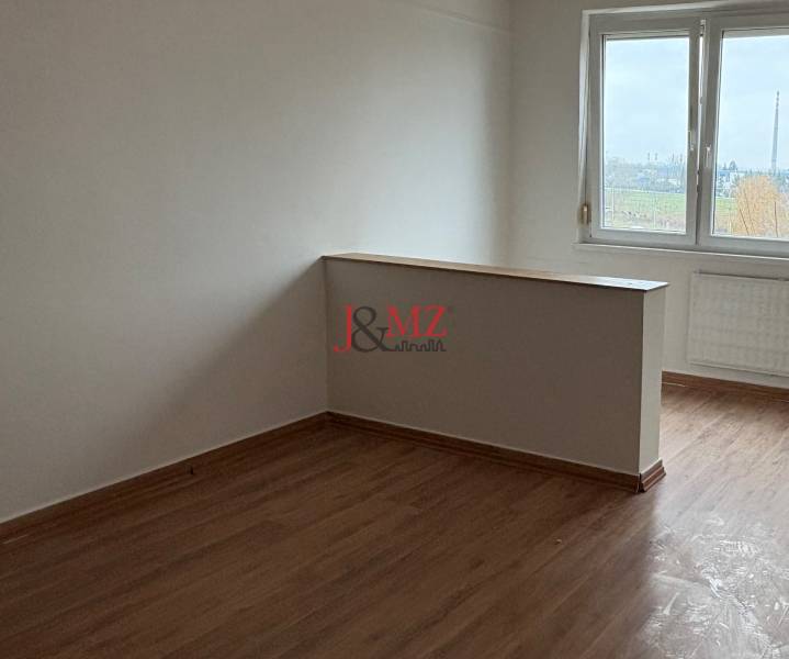 A room in a 2-room apartment with a wooden decor floor and a view from the window.