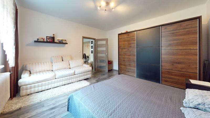 Bedroom in a family house with a spacious wardrobe and a floor with a wooden decor.