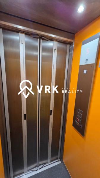 Elevator in the building, with buttons and a display showing the fifth floor.